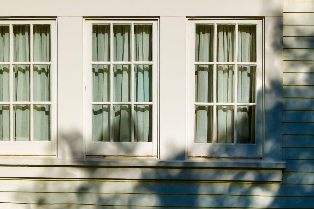 Exterior home windows and siding showing clean surfaces suitable for soft washing instead of high-pressure cleaning.