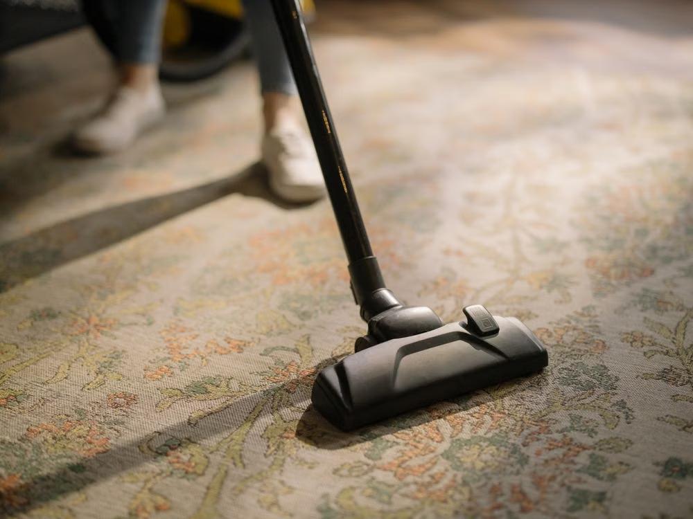 close-up of a person vacuuming an area rug