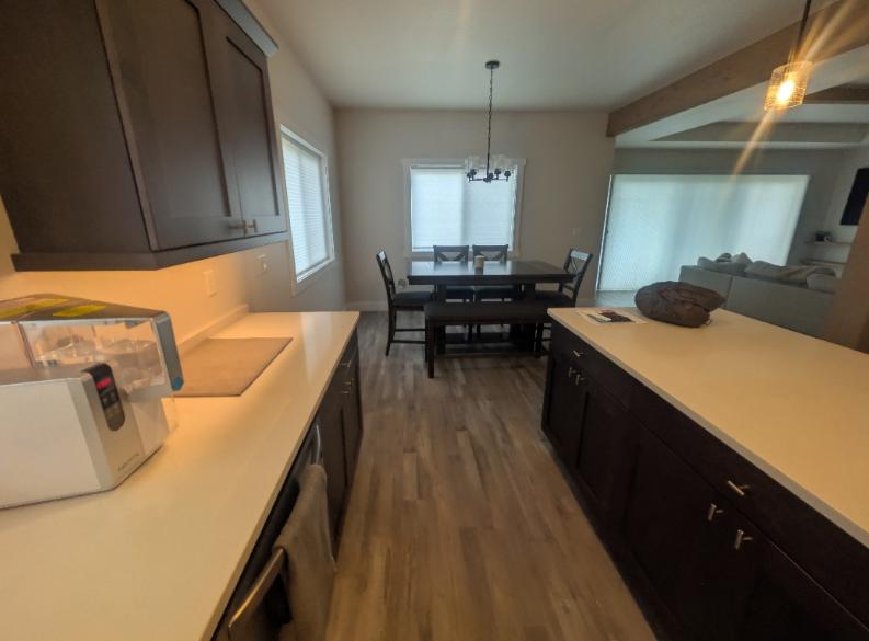 An image of a clean kitchen with clear countertops and an adjoining dining area
