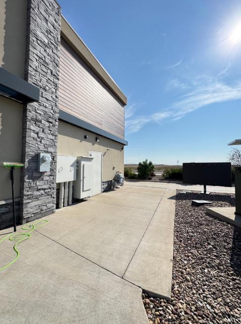 An image of a concrete service walkway beside a commercial building