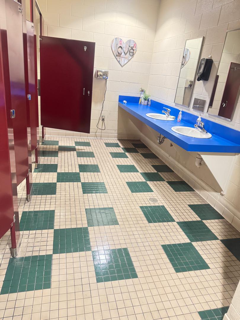 a tiled restroom with dirty grout lines