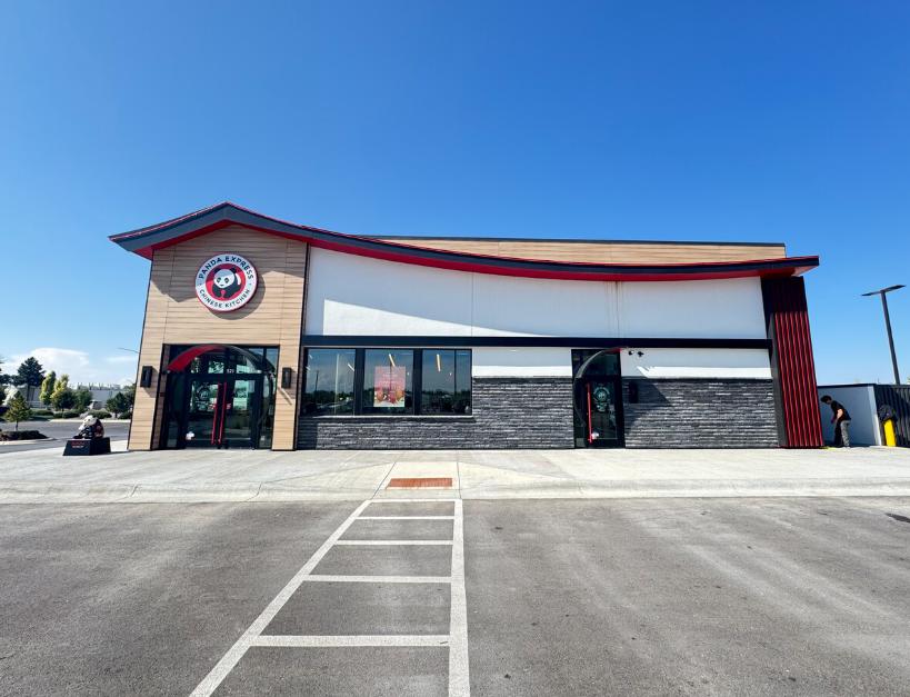 An image of a clean retail storefront with large windows and paved exterior areas
